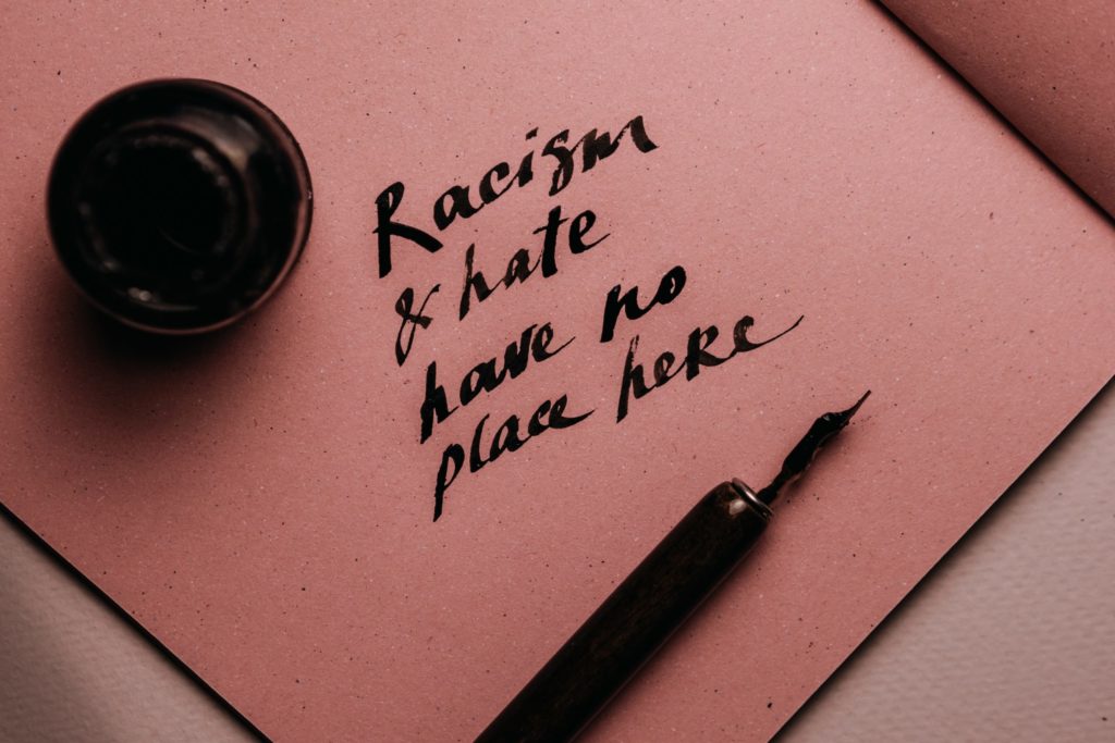 Handwritten message "racism and hate have no place here"